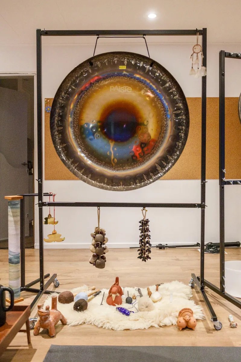 Grote Paiste-gong met klankinstrumenten op een schapenvacht
